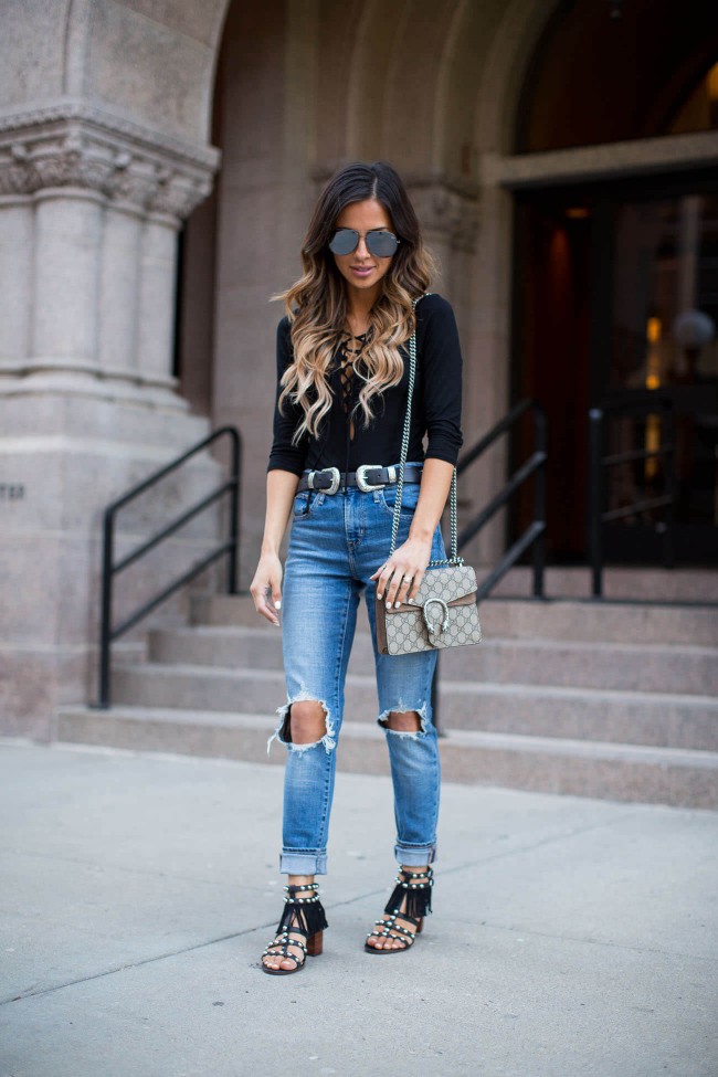 Fashion blogger wearing a black bodysuit and ripped jeans