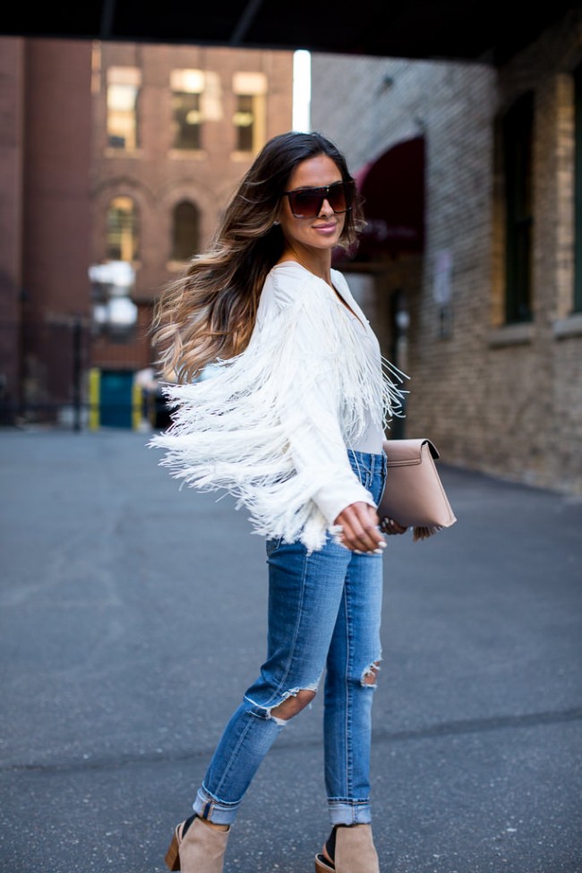 Minnesota fashion blogger in a fringe jacket and ripped jeans