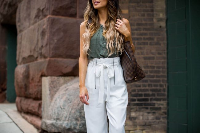 fashion blogger mia mia mine in white trousers and a lace-up olive top