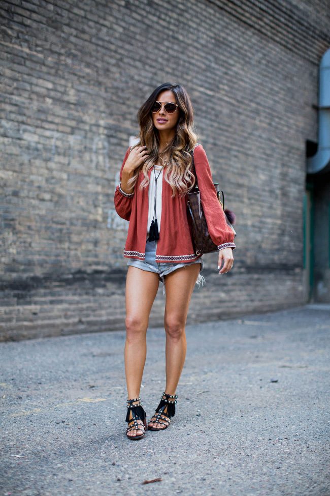 fashion blogger mia mia mine in an embroidered top from H&M and cut off jean shorts