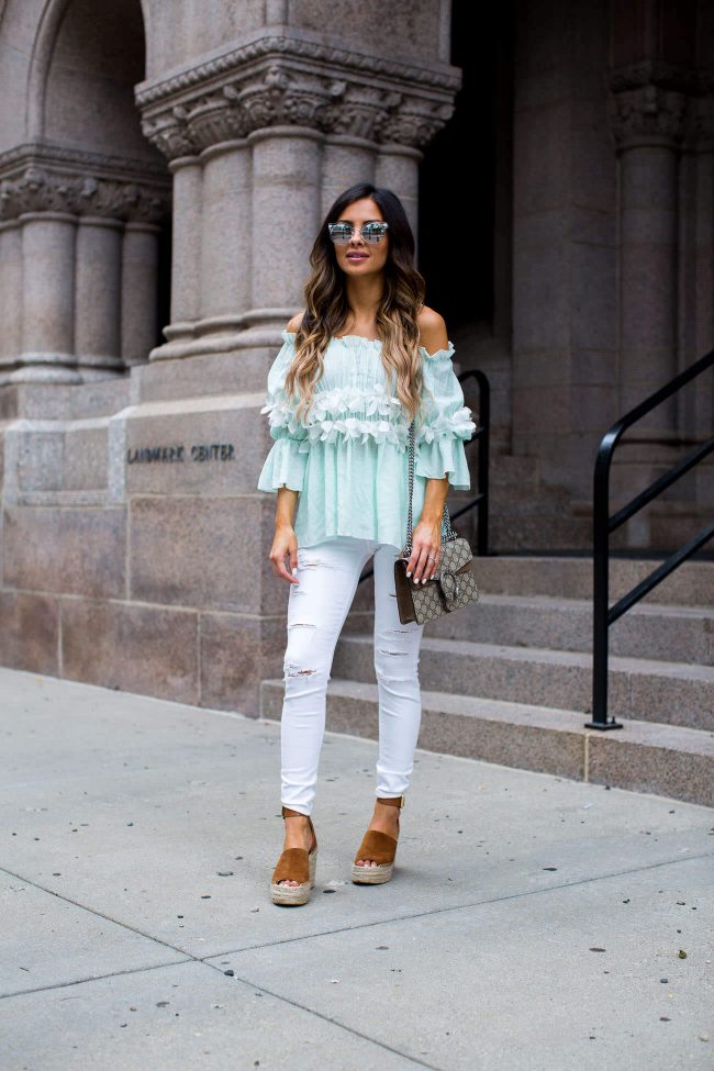 fashion blogger mia mia mine in an off-the-shoulder top and white jeans from topshop