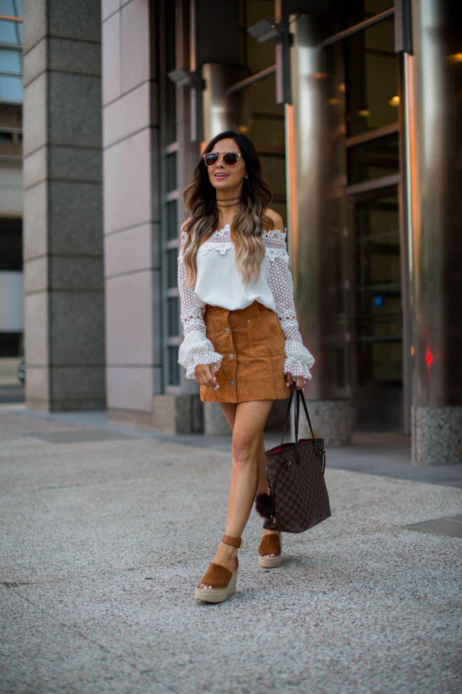 fashion blogger mia mia mine wearing a white off-the-shoulder lace top and suede mini skirt