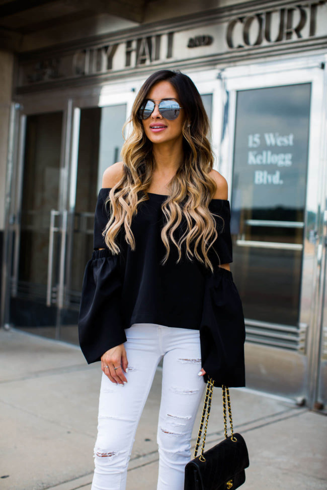 fashion blogger mia mia mine wearing a black top and white jeans from nordstrom