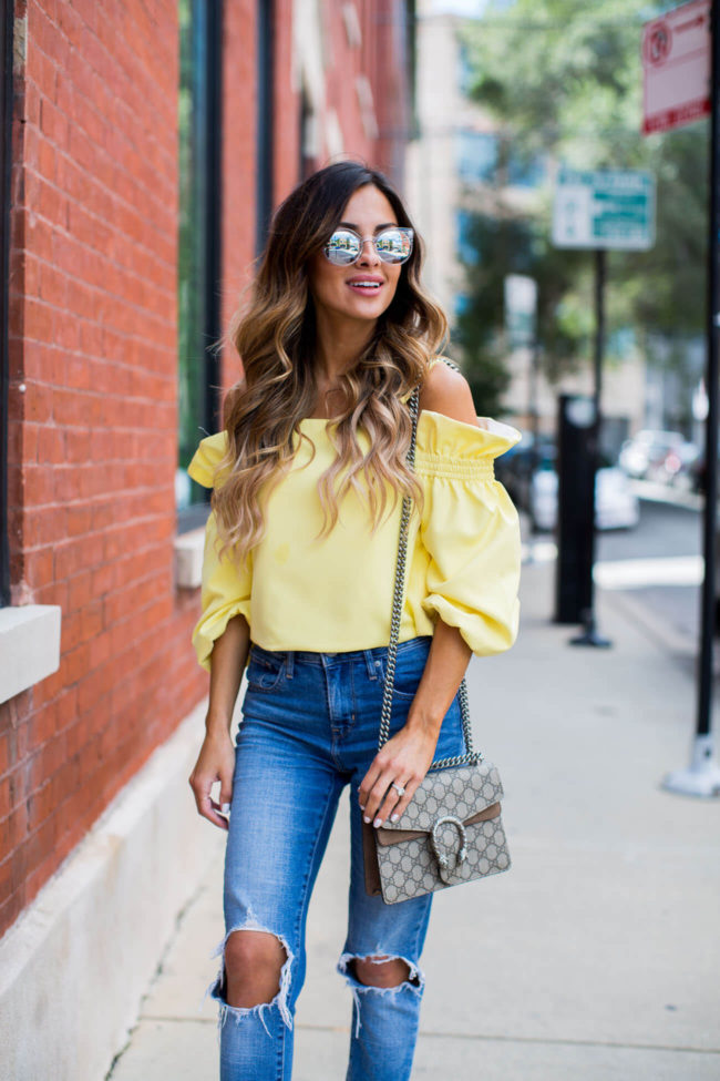 fashion blogger mia mia mine in a yellow off the shoulder top from shopbop and levis jeans