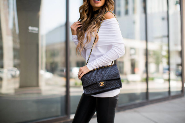 fashion blogger mia mia mine wearing a white off-the-shoulder top and leather pants