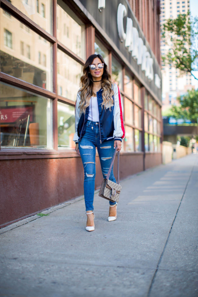 fashion blogger mia mia mine in ripped jeans and a brunch bomber jacket