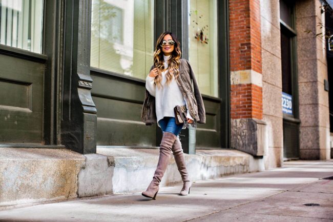 fashion blogger mia mia mine wearing a white turtleneck sweater and gray over-the-knee boots by stuart weitzman