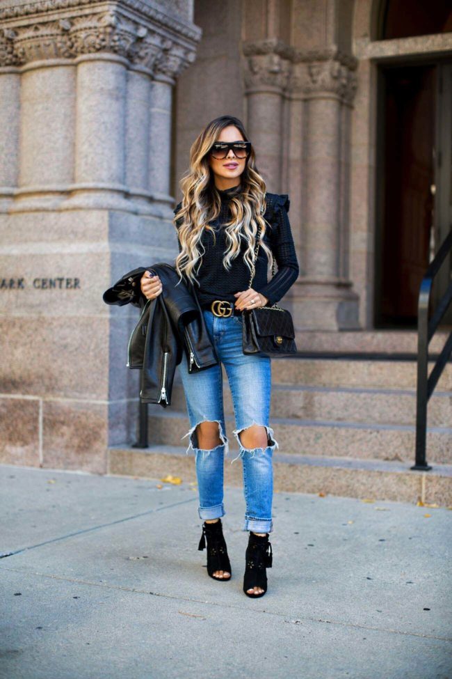 fashion blogger mia mia mine wearing a black turtleneck sweater from nordstrom, levi's jeans and a chanel bag
