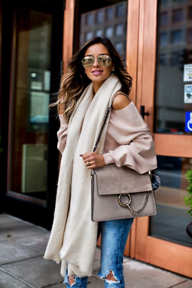 fashion blogger mia mia mine wearing a free people pink off-the-shoulder sweater and an ivory scarf