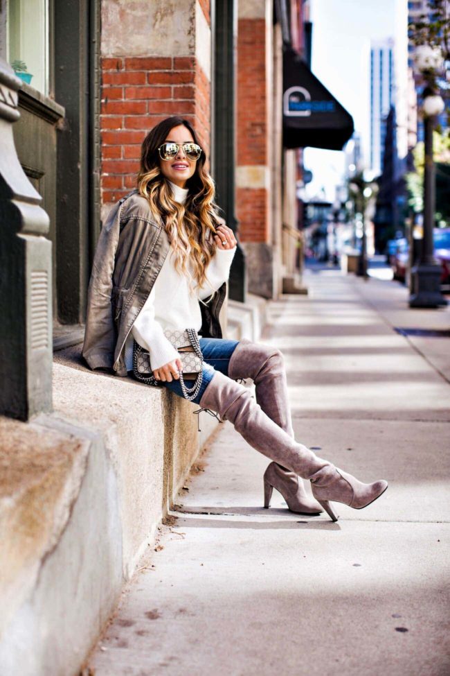 fashion blogger mia mia mine wearing a white turtleneck sweater and topo highland boots by stuart weitzman