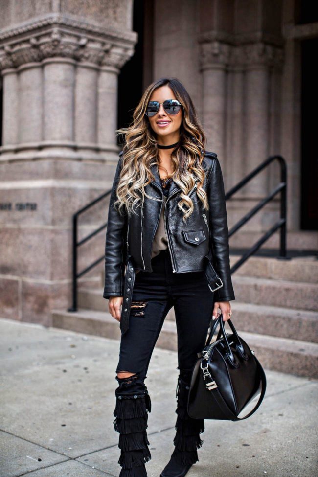 fashion blogger Mia Mia Mine wearing minnetonka moccasin fringe boots and a leather jacket