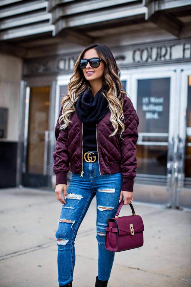 fashion blogger mia mia mine wearing an express burgundy bomber jacket and a black turtleneck sweater