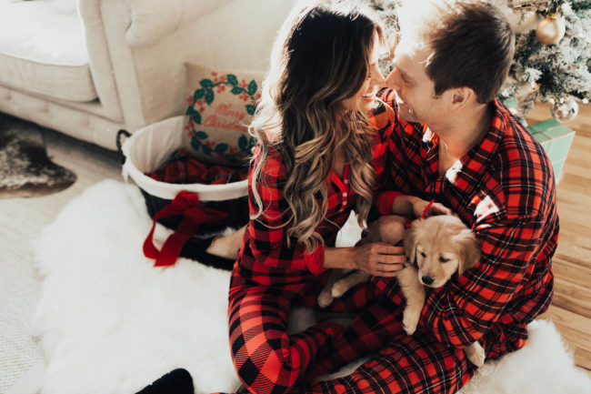 fashion blogger mia mia mine wearing plaid pajamas at home with her husband for christmas