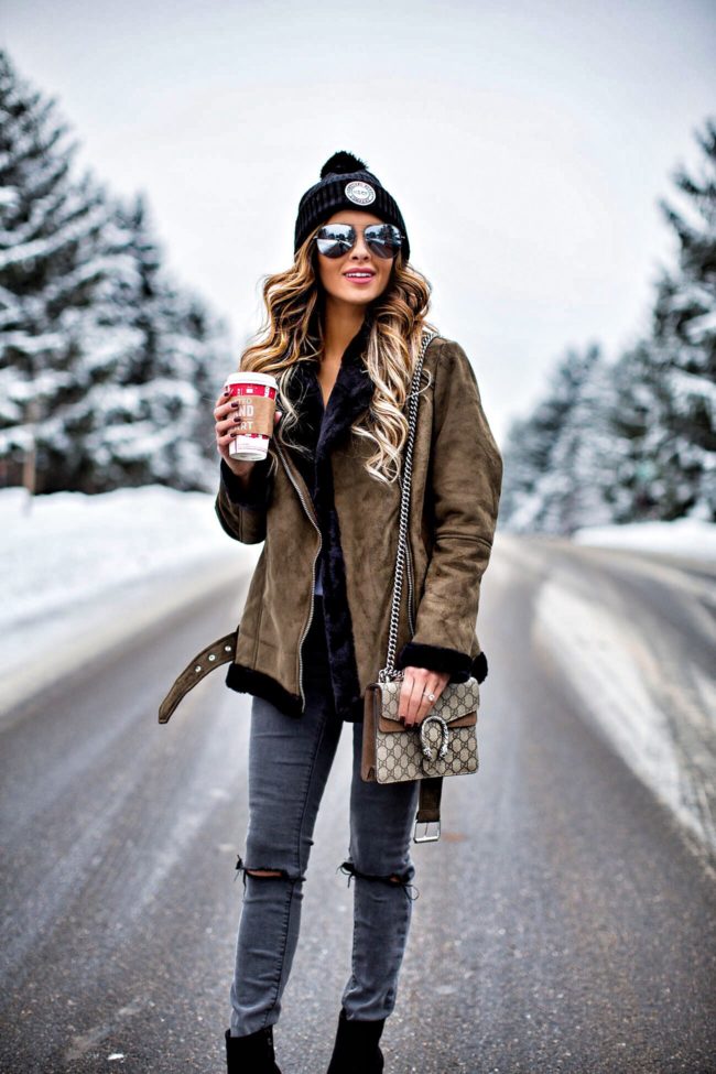fashion blogger mia mia mine wearing a shearling olive jacket and a black beanie hat
