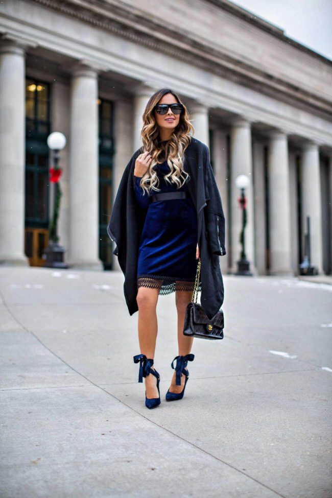 fashion blogger mia mia mine wearing a sapphire blue velvet dress and blue ribbon heels