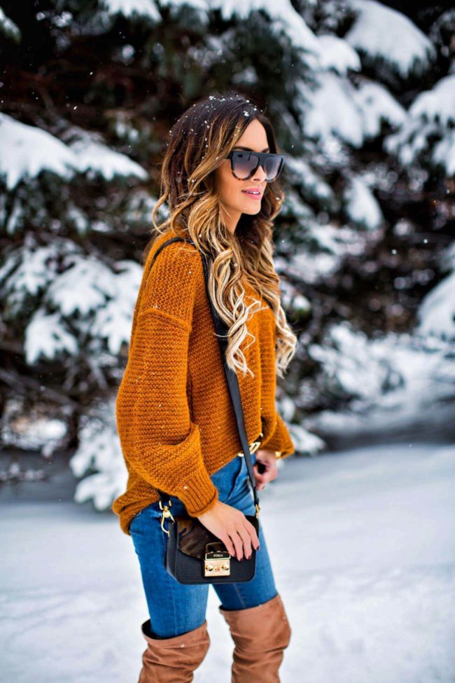 fashion blogger mia mia mine wearing an orange free people sweater and a furla bag