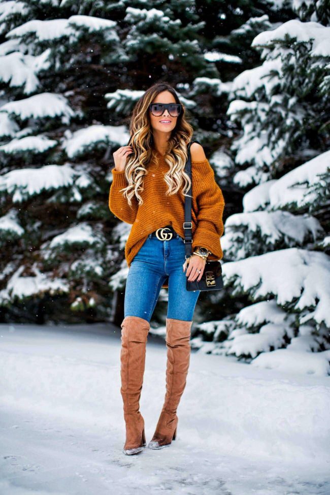 fashion blogger mia mia mine wearing an off-the-shoulder free people sweater and a gucci double g buckle belt
