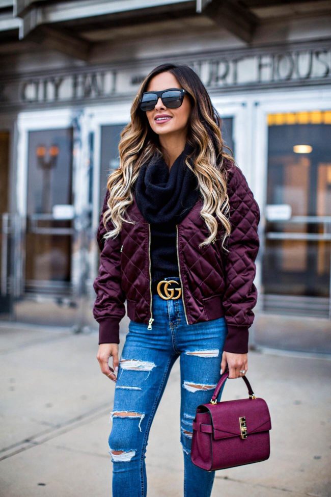 fashion blogger mia mia mine wearing a burgundy bomber jacket from express and a gucci belt
