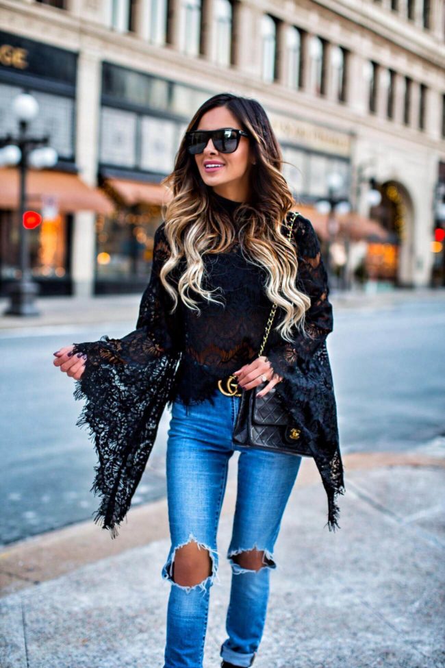 fashion blogger mia mia mine wearing a black lace bell sleeve top from shopbop