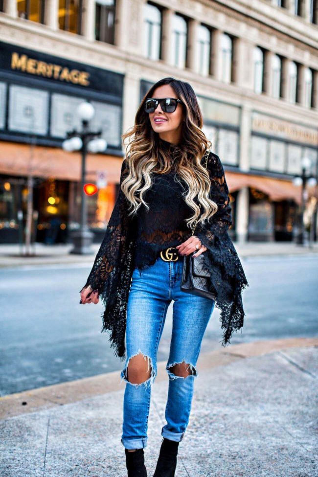 fashion blogger mia mia mine wearing a black lace bell sleeve top from revolve