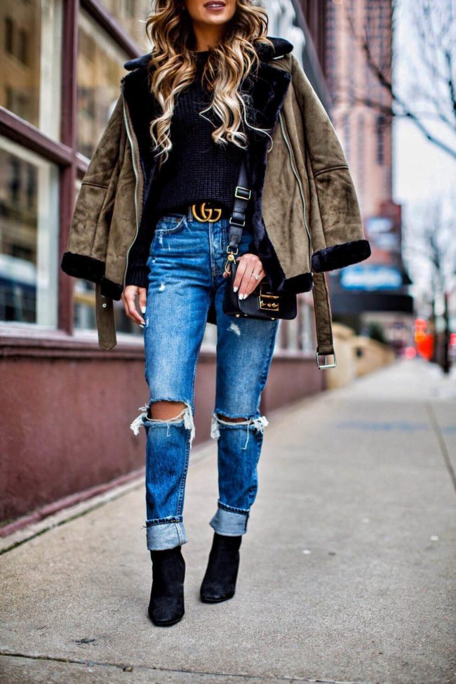 fashion blogger mia mia mine wearing ripped jeans from revolve and a gucci double g buckle belt