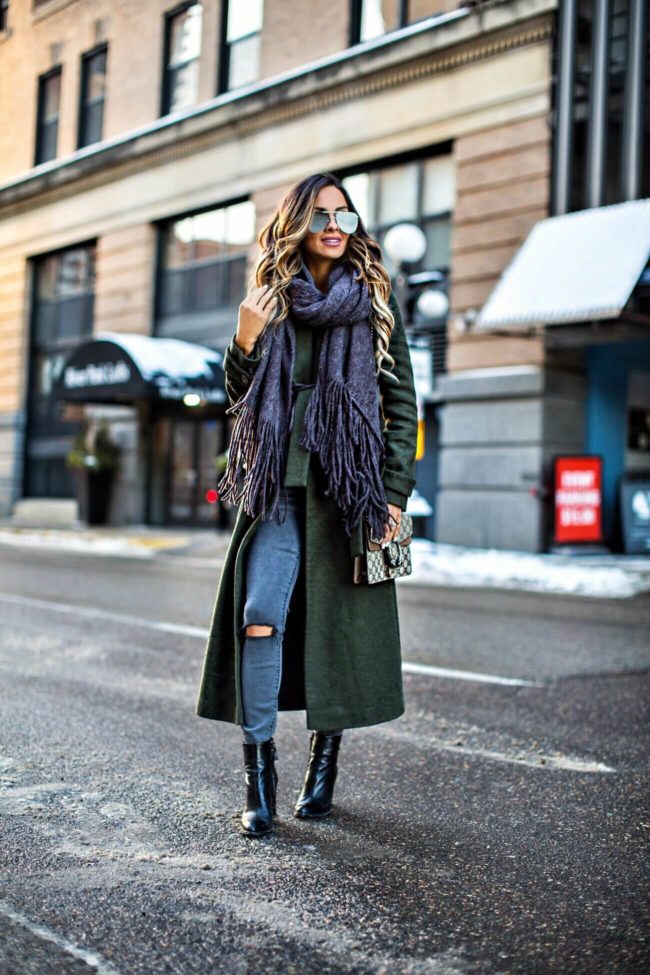 fashion blogger mia mia mine wearing a green trench coat and gray jeans