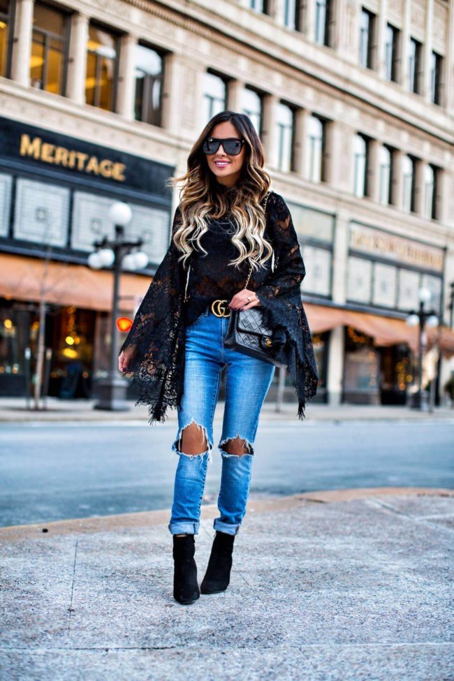 fashion blogger mia mia mine wearing a black lace bell sleeve top from shopbop and a gucci belt