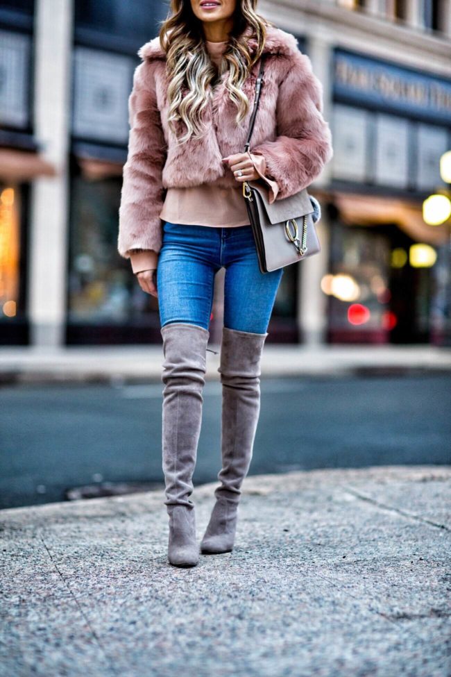 fashion blogger mia mia mine wearing a blush faux fur jacket and stuart weitzman over-the-knee boots