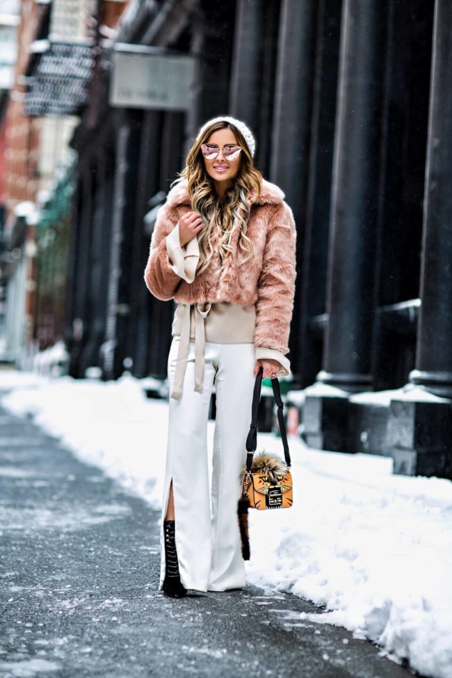 fashion blogger mia mia mine wearing a blush jacket from asos and white pants from revolve at new york fashion week