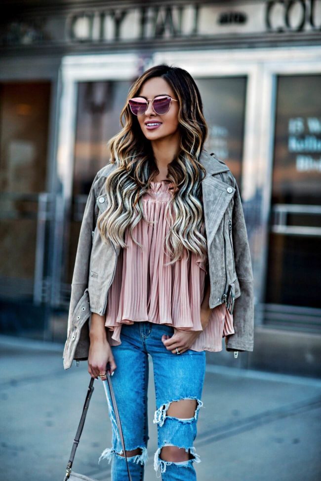 fashion blogger mia mia mine wearing a pink top and a blank denim suede moto jacket from revolve