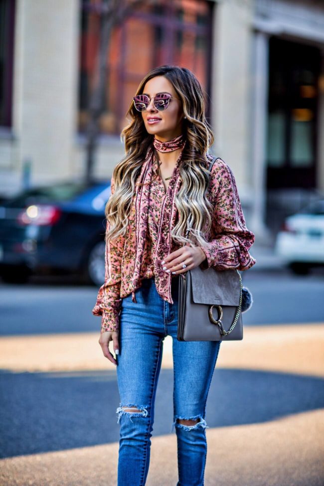 fashion blogger mia mia mine wearing a pink floral print top by free people and a chloe faye medium bag