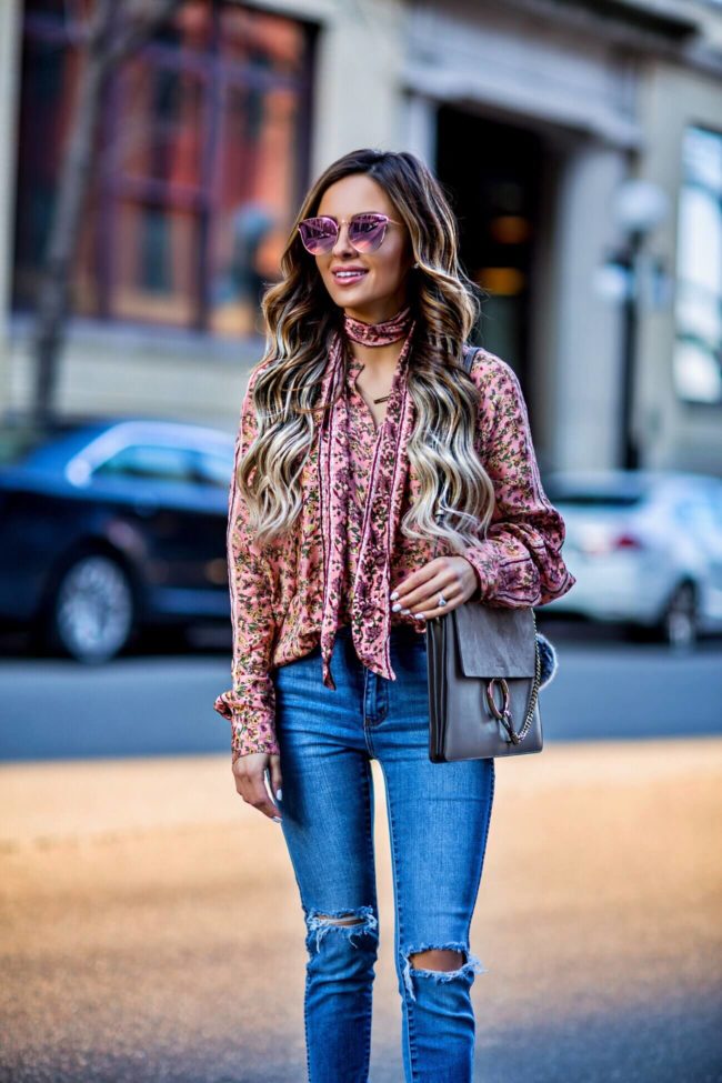 fashion blogger mia mia mine wearing a pink floral print top by free people and a chloe faye medium bag