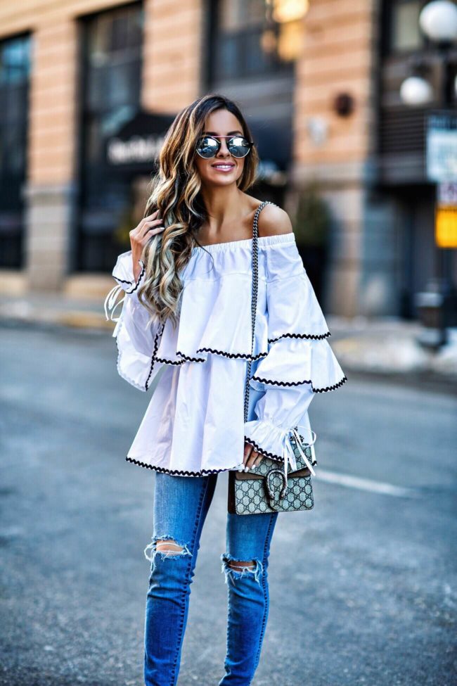 fashion blogger mia mia mine wearing a white ruffled top and a gucci dionysus bag