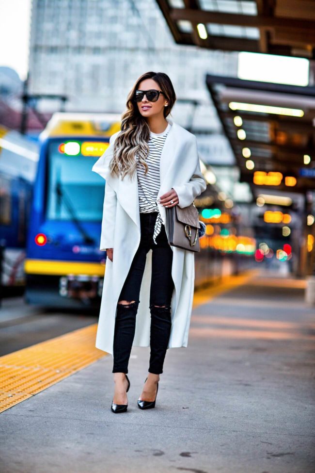 fashion blogger mia mia mine wearing a white duster coat and black ripped topshop jeans