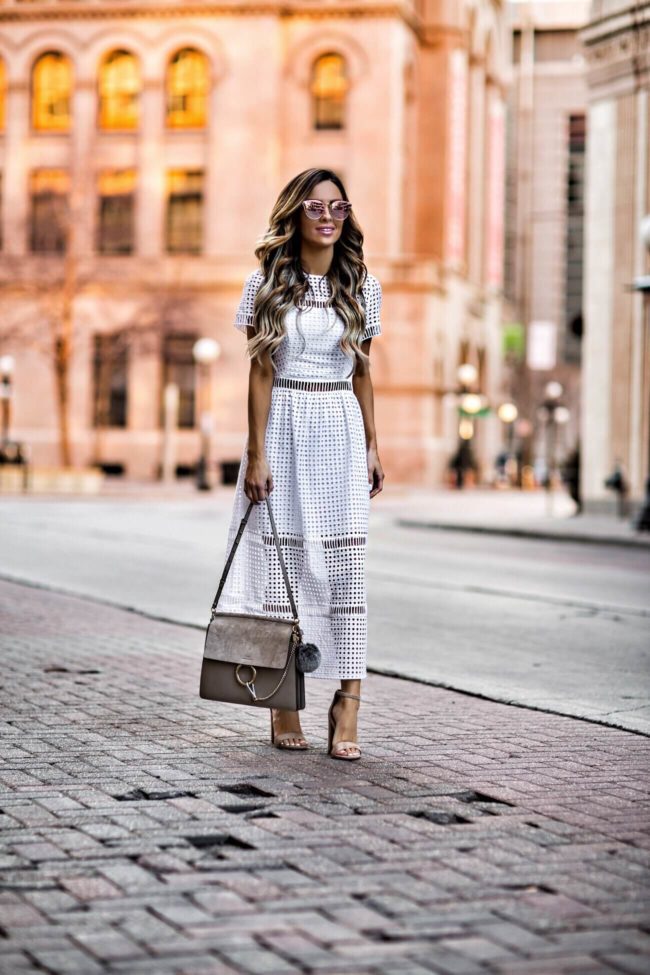 fashion blogger mia mia mine wearing a white eyelet dress and chloe faye bag