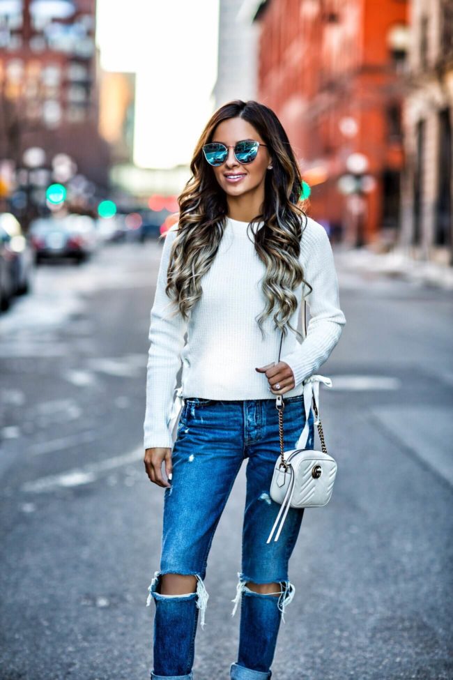fashion blogger mia mia mine wearing a white lace-up sweater and blue sunglasses from nordstrom