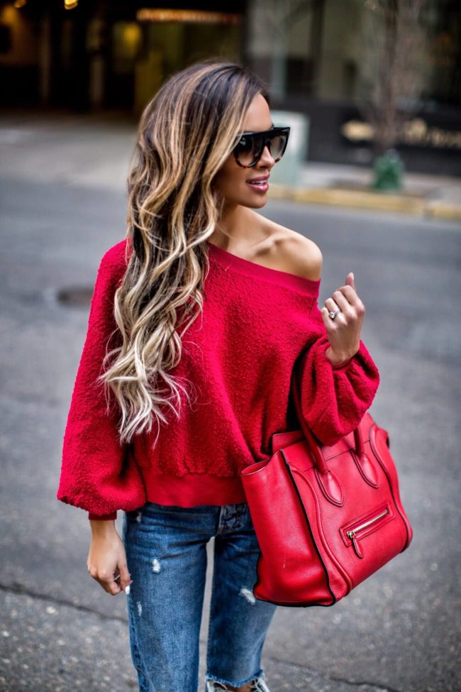 fashion blogger mia mia mine wearing a red off-shoulder sweatshirt from nordstrom