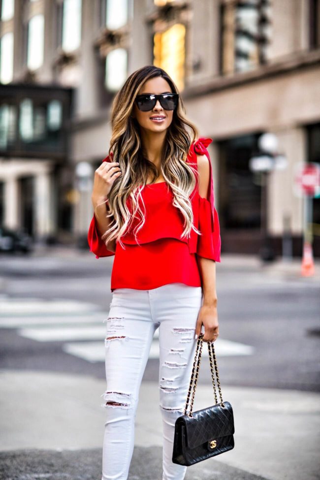 fashion blogger mia mia mine wearing a red bow top and white ripped jeans by topshop
