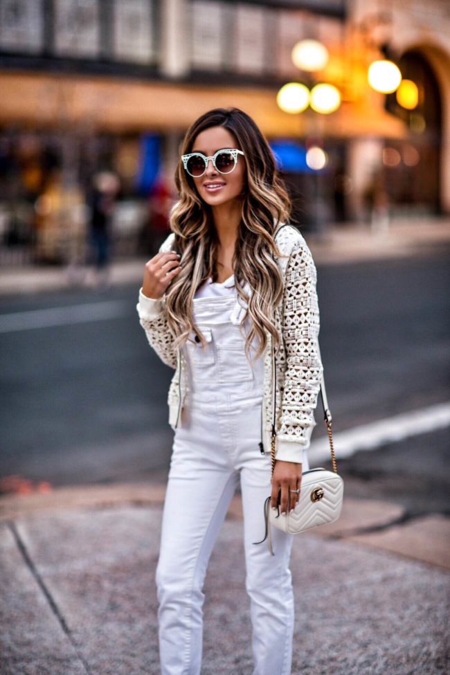 fashion blogger mia mia mine wearing a lace bomber jacket by bb dakota from shopbop and white overalls from free people