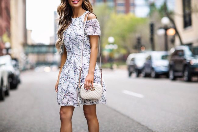 fashion blogger mia mia mine wearing a floral mini dress from revolve