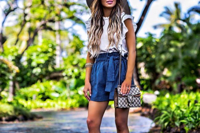 fashion blogger mia mia mine wearing striped high waisted shorts and a gucci bag in hawaii