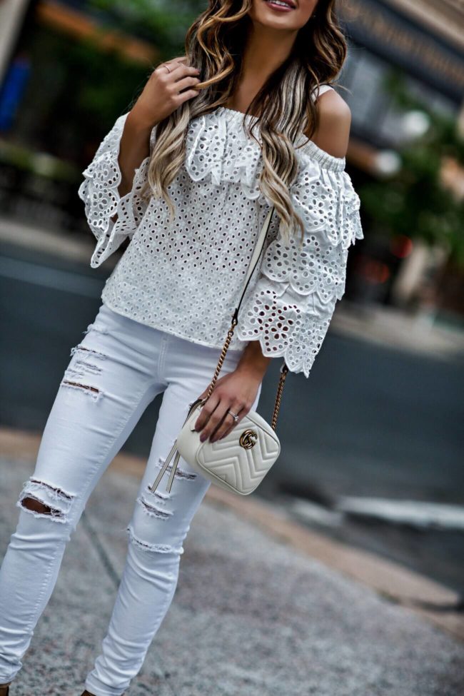 fashion blogger mia mia mine wearing a white eyelet cold shoulder top from revolve and a gucci white marmont bag