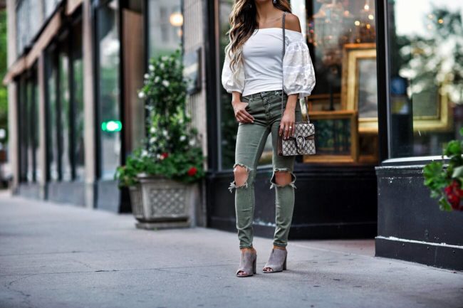 fashion blogger mia mia mine wearing a white off-the-shoulder top and a gucci dionysus bag