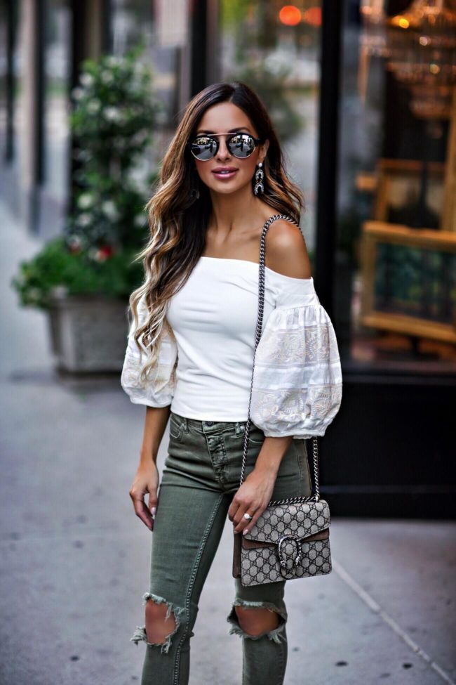 fashion blogger mia mia mine wearing a free people white statement sleeve top and illesteva sunglasses