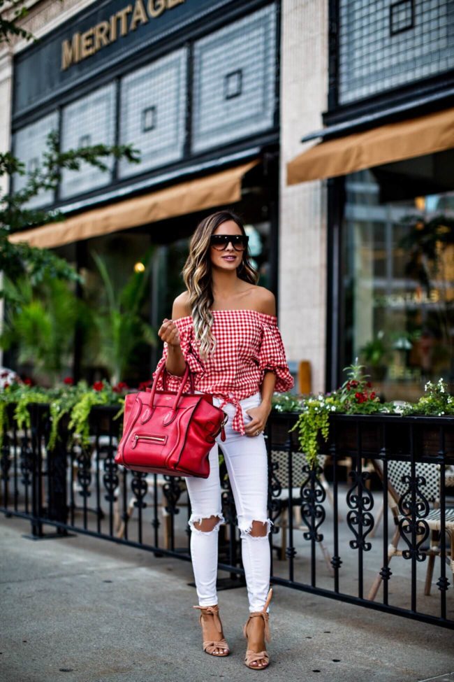 fashion blogger mia mia mine wearing a red and white gingham top and white free people jeans