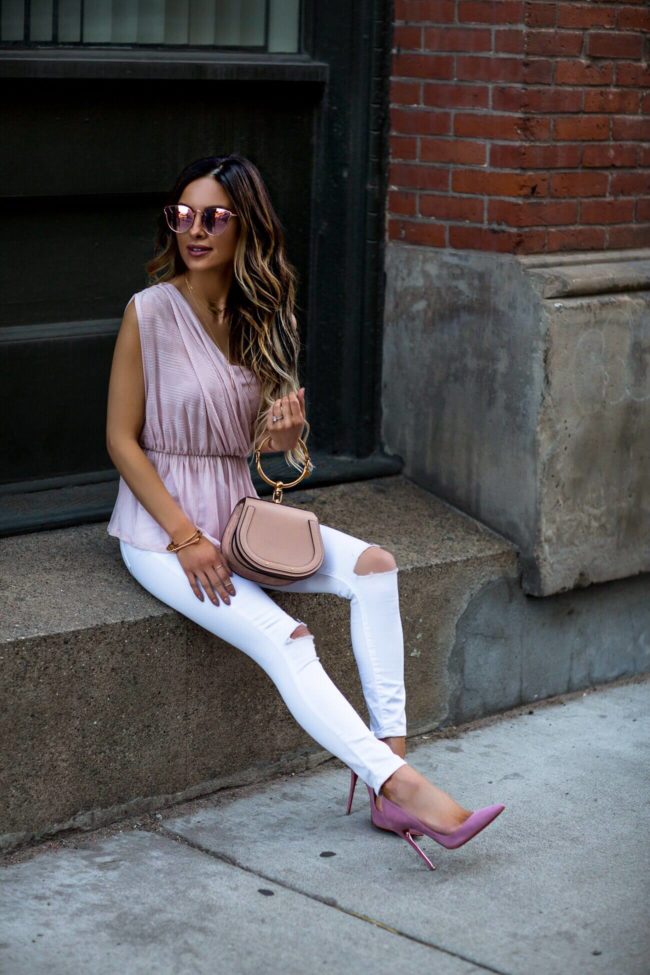 fashion blogger mia mia mine wearing a pink free people top and white topshop denim