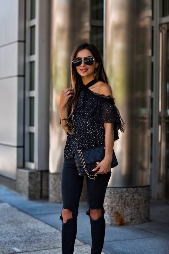 fashion blogger mia mia mine wearing a cutout lace top and a chanel double flap bag