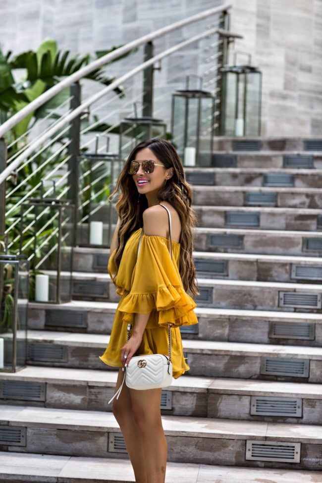 fashion blogger mia mia mine wearing a yellow romper from revolve in miami