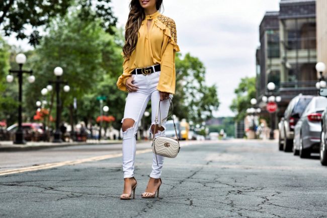 fashion blogger mia mia mine wearing a yellow free people top from macy's and white denim jeans