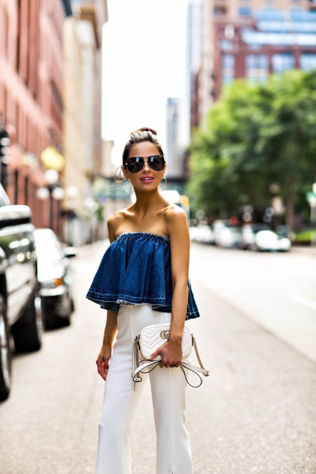fashion blogger mia mia mine wearing a strapless denim top and white pants from revolve